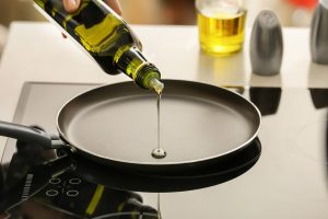 olive oil pouring onto a frying pan