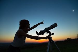 woman looking at the stars with telescope