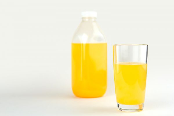 glass of orange drink with pitcher