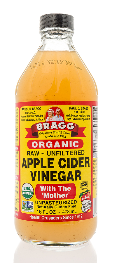 A bottle of Bragg apple cider vinegar with mother on an isolated background.