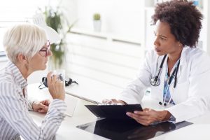 African American female doctor discusses results with Caucasian senior female