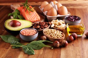 selection of heart healthy foods like spinach, avocado, and salmon