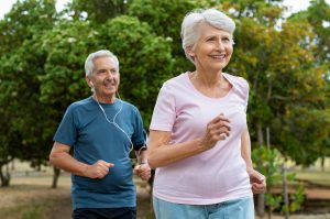 senior Caucasian couple running outside