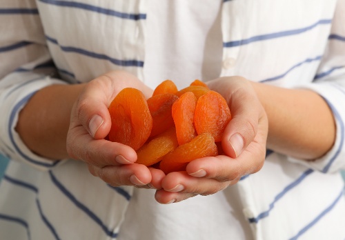 hands holding dried apricots