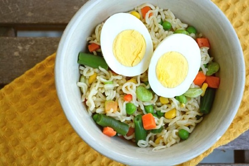 Bowl of ramen noodles with colorful veggies and a hardboiled egg