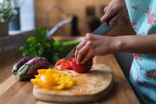 hands chopping colorful vegetables on a cutting board