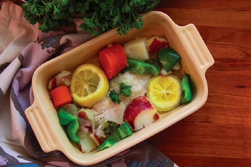 white fish with vegetables in a baking dish