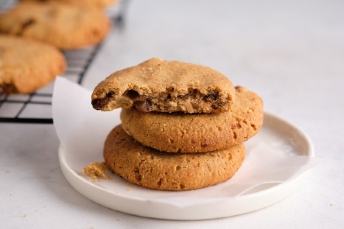 Stack of three pumpkin cookies on a small white dish