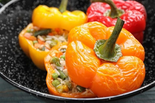 Colorful bell peppers baked and stuffed with a vegetable and rice mix