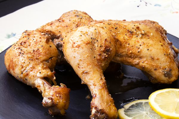 chicken on black plate with lemon