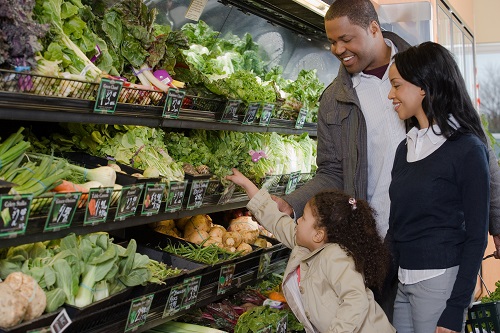 family shopping in a supermarket for vegetables