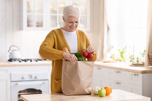 Smiling Senior Unpacking Groceries and produce