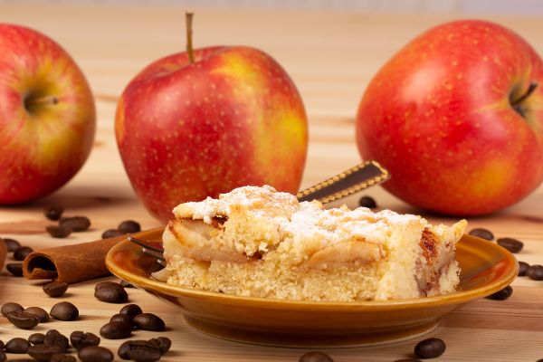 coffee cake on a plate with 3 apples and coffee beans