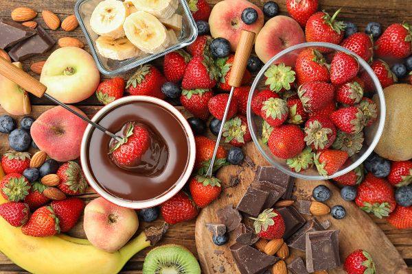 assorted fruit with fudge sauce in glass bowl