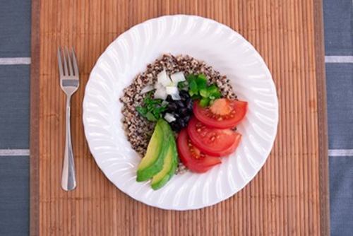 black beans, quinoa, and various vegetables in a white bowl