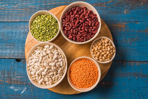 Turntable of different sized bowls filled with colorful dried beans and lentils