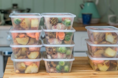 Three stacks of leftovers in clear containers on a kitchen counter