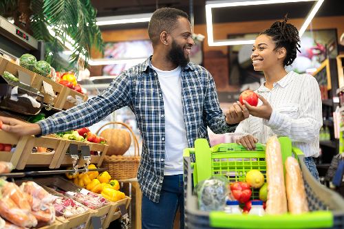 young couple shopping for produce at the grocery store 