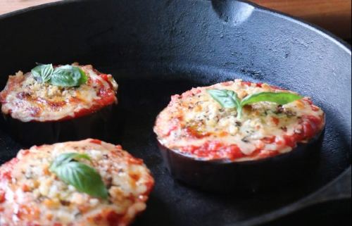 eggplant slices topped with marinara sauce, cheese, and basil leaves and sat in a cast iron pan