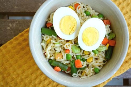 ramen noodles with mixed veggies topped with a boiled egg 