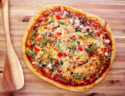 veggie pizza on a wooden cutting board