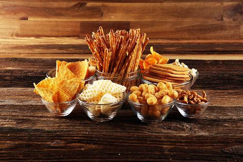 bowls of salty snack foods on a wooden table