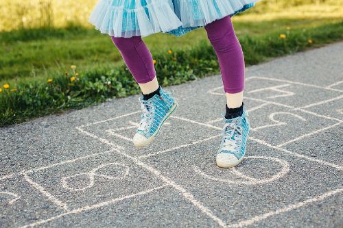 close up of a child playing hopscotch