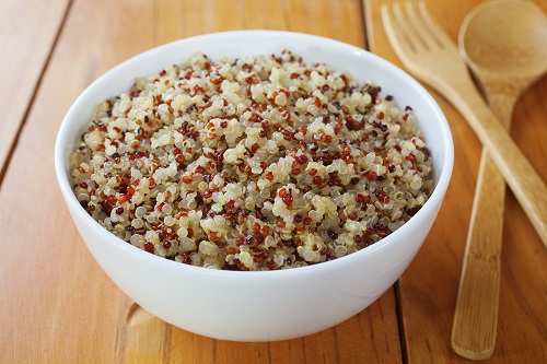 Bowl of multicolored quinoa in a white bowl.