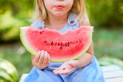 little girl eating a watermelon