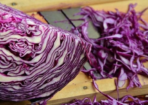 sliced red cabbage on a wooden cutting board