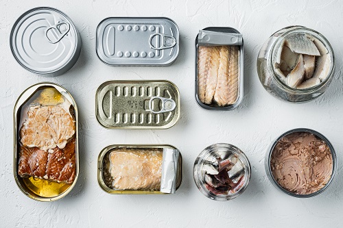Canned fish on white background, top view flat lay