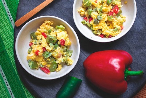 Two bowls of scrambled eggs with nopales and red bell peppers