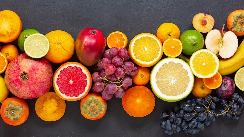 Fresh assorted colorful fruits laid out on a dark backgroundFresh assorted colorful fruits laid out on a dark background