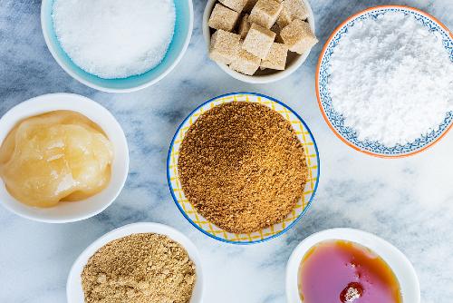 aerial view of colorful bowls filled with different types of sugar