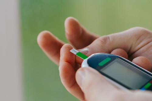 hands holding a blood sugar monitor