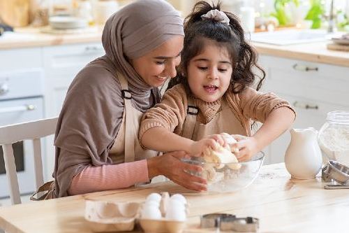 mother and daughter baking in the kitchen together