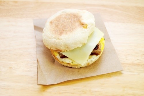 english muffin with sausage, egg and cheese in between the muffin halves