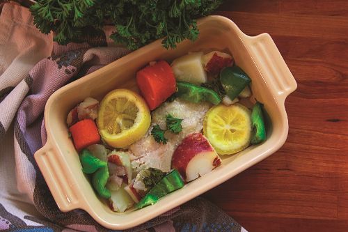 Summer salad in a bowl on a table covered with a striped table cloth