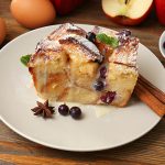 piece of baked apple bread pudding on wooden table