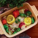 white fish with vegetables in a baking dish