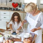 little girl helps grandma in the kitchen.