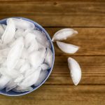 A Blue Bowl Full Of Ice Cubes On A Wooden Table