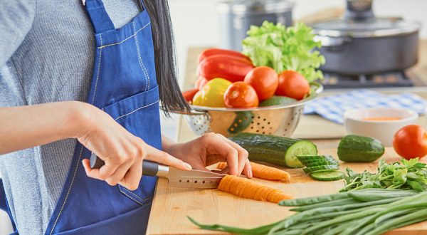 A young woman prepares food in the kitchen.