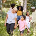 Senior African American woman walking with family on a nature path