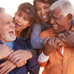 two smiling elderly couples outside