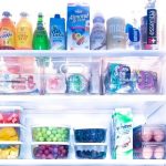 Clean and organized fridge of bottles, bread, fruit, and eggs.