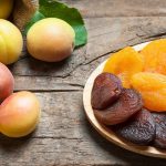 fresh and dried apricots on a wooden background