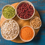 beans and peas in bowls on blue background