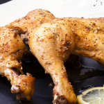 chicken on black plate with lemon