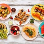 colorful plant based summer dishes arranged on a wooden table surface